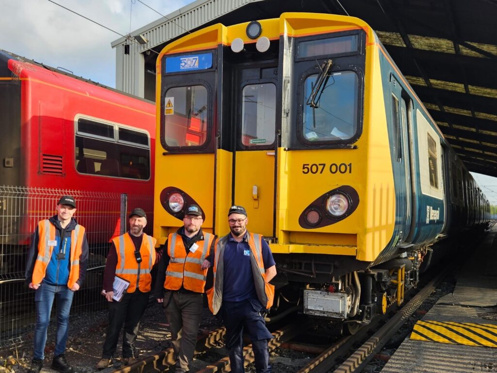 Members of Team 507 pose in front of 507001 while preparing the unit for its test track run